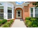 Close-up of the home's entrance featuring a decorative storm door, brick archway, and manicured landscaping at 606 Corrigan Way, Cary, NC 27519