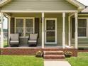 Inviting front porch with brick trim, rocking chairs and decorative plants at 635 Raymond Dr, Wendell, NC 27591