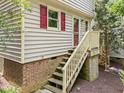 Charming elevated entrance with wooden stairs and brick foundation details at 6422 English Oaks Dr, Raleigh, NC 27615