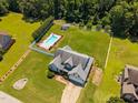 Expansive property featuring a backyard pool, fenced yard, and lush landscaping as seen from above at 6965 Ogburn Farms Dr, Willow Springs, NC 27592
