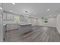 Open-concept kitchen featuring new gray cabinets, a center island, and stainless steel appliances at 703 Whitsett Ave, Gibsonville, NC 27249