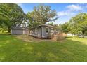 View of the home's rear exterior and large backyard with a detached garage at 703 Whitsett Ave, Gibsonville, NC 27249
