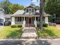 Charming craftsman home featuring a covered front porch with red shutters and brick-lined steps at 708 Parker St, Durham, NC 27701