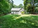 Green backyard with a deck, a white fence, and mature trees surrounding the property at 8504 Carlton Oaks Dr, Wake Forest, NC 27587