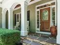 Inviting front porch with stone steps, rocking chairs, and decorative wooden door at 8504 Carlton Oaks Dr, Wake Forest, NC 27587