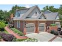 Exterior showcasing a brick home with attached garage and beautiful landscaping with a brick lined walkway at 8851 Mariner Dr, Raleigh, NC 27615