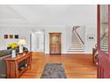 Inviting living room with hardwood floors, staircase, and view of the home's front door at 8851 Mariner Dr, Raleigh, NC 27615
