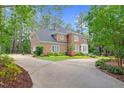 Beautiful brick home with a circular driveway, lush lawn and mature landscaping at 105 Bathgate Ln, Cary, NC 27513