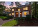 Elegant two-story brick home featuring a columned porch and bay window at twilight at 105 Bathgate Ln, Cary, NC 27513