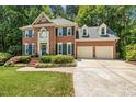 Traditional brick home with two-car garage, manicured lawn, and front brick walkway at 105 Windfall Ct, Cary, NC 27518