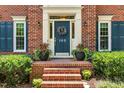 Close up of the front door, brick steps, and detailed landscaping at 105 Windfall Ct, Cary, NC 27518