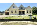 New construction home featuring yellow siding, black window trim, a covered entry, and a two car garage at 110 Broadleaf Ln, Louisburg, NC 27549