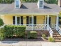 Close-up of a home's facade featuring a decorative white porch railing and brick steps at 11901 N North Exeter Way Way, Raleigh, NC 27613