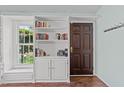 An interior entryway is highlighted by a built-in bookcase and hardwood floors at 11901 N North Exeter Way Way, Raleigh, NC 27613