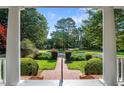 View of landscaped front yard through front porch columns at 12201 Lockhart Ln, Raleigh, NC 27614