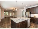 Spacious kitchen with granite counters, stainless appliances, and an open view to the living room at 12421 Angel Vale Pl, Durham, NC 27703