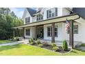 Side view of a lovely two-story home featuring a welcoming porch with sturdy support pillars at 125 Attena Way, Zebulon, NC 27597