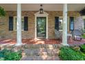Inviting brick porch with white columns, seating, and a classic brick-paved surface at 1311 Norton St, Durham, NC 27701