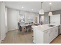 Bright dining area with a table for six, open to the kitchen with quartz countertops at 1472 Hasse Ave, Apex, NC 27502