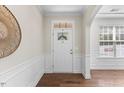 Bright foyer featuring hardwood floors, decorative wainscoting, and an arched doorway at 1705 Bodwin Ln, Apex, NC 27502