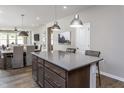 Bright, open kitchen with an island and bar stools, flowing into a dining area and living space at 181 Churchill Way, Clayton, NC 27520