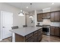 Well-lit kitchen showcasing a center island with seating, stainless steel appliances, and ample cabinet space at 181 Churchill Way, Clayton, NC 27520