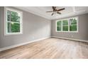 Bedroom with ample natural light from several windows, neutral walls, and wood-look floors at 190 Whistlers Cv, Louisburg, NC 27549