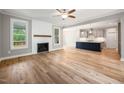 Open concept living room featuring fireplace with mantle, wood-look flooring, and view into kitchen at 190 Whistlers Cv, Louisburg, NC 27549