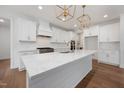 Modern kitchen with white cabinets, stainless steel appliances, and a large island at 200 Whistlers Cv, Louisburg, NC 27549