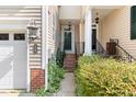 Welcoming townhouse entrance with brick stairs, garden, and modern outdoor lighting creating a warm ambiance at 204 Towne Ridge Ln, Chapel Hill, NC 27516