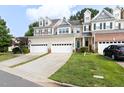 Inviting townhouse featuring attached garages, a well-manicured lawn, and attractive curb appeal in a lovely neighborhood at 204 Towne Ridge Ln, Chapel Hill, NC 27516