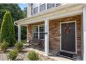 Inviting front porch with stone accents, seating, and a welcoming door, creating a warm and inviting entry at 206 Vandercroft Way, Bunnlevel, NC 28323
