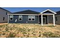 Home exterior with blue siding, a dark roof, and white trim, awaiting landscaping at 246 Norman Ave, Lillington, NC 27546