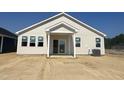 Rear view of a one-story home with siding, white trim, a patio and a plain yard under construction at 256 Norman Ave, Lillington, NC 27546