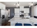 Modern kitchen features stainless steel appliances, white cabinetry, granite counters, and a spacious center island at 2799 Cassius Dr, Apex, NC 27502