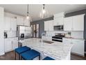Modern kitchen features stainless steel appliances, white cabinetry, granite counters, and a spacious center island at 2799 Cassius Dr, Apex, NC 27502