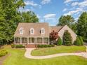 Aerial view of a house with a charming front porch, mature trees, and a winding walkway leading to the entrance at 2945 Chimney Hill Trl, Rocky Mount, NC 27804