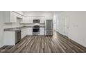 Modern kitchen featuring white cabinets, stainless steel appliances, and elegant gray countertops at 3010 Fulong Dr, Durham, NC 27704