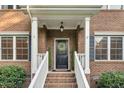 Close-up of a brick home's front door with a decorative wreath and manicured landscaping at 3650 Pleasants Ridge Dr, Wake Forest, NC 27587