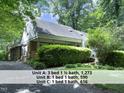 Exterior view of the triplex showing brick and white siding and mature trees at 407 Coolidge St # A, Chapel Hill, NC 27516
