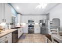 Spacious kitchen with white cabinets, stainless steel appliances, and tile flooring at 413 Braxman Ln, Holly Springs, NC 27540