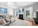 Cozy living room featuring a fireplace, neutral decor, and plenty of natural light at 413 Braxman Ln, Holly Springs, NC 27540