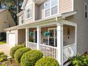 Inviting front porch with a cozy seating area and beautifully landscaped front yard at 4600 Landover Dale Dr, Raleigh, NC 27616
