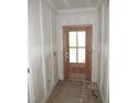 Entryway featuring a solid wood front door, framed by bright white walls with clean trim work at 53 Stonewood Loop Ln, Henderson, NC 27537