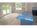 Bright, airy kitchen with island, white cabinets, and a view to the backyard through glass doors at 53 Stonewood Loop Ln, Henderson, NC 27537