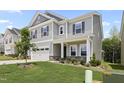 Gray two-story home with stone accents and manicured lawn shows curb appeal and modern design at 544 Tanner Lake Ln, Raleigh, NC 27610