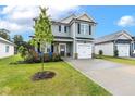 Two-story home with light gray siding, a front porch, and a well-maintained lawn and driveway at 553 Sturgeon St, Smithfield, NC 27577