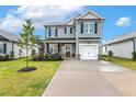 View of a two-story home featuring light gray siding, a front porch, and a concrete driveway at 553 Sturgeon St, Smithfield, NC 27577