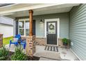 Close-up of a charming front porch with a door wreath, blue chairs, and brick accents at 553 Sturgeon St, Smithfield, NC 27577