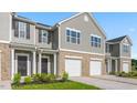 Attractive townhome featuring gray siding, brick base, and attached garages at 5560 Henley Ridge Dr # 187, Graham, NC 27253
